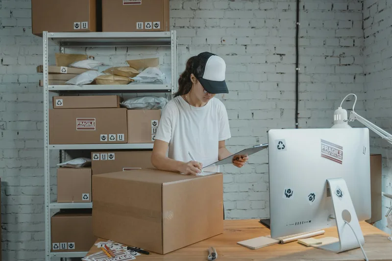 Indonesian ecommerce seller managing inventory and packaging orders at a small business warehouse