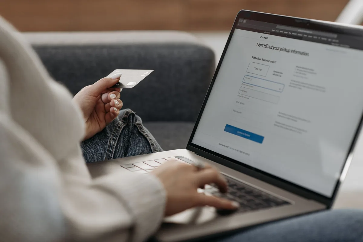 Filipino online shopper using a credit card and laptop to complete an ecommerce checkout