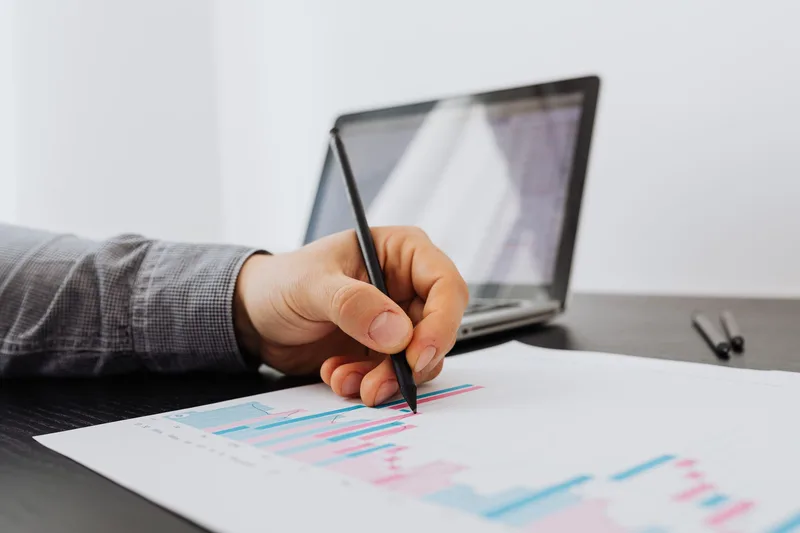 Business owner reviewing payment settlement data and financial charts on a laptop