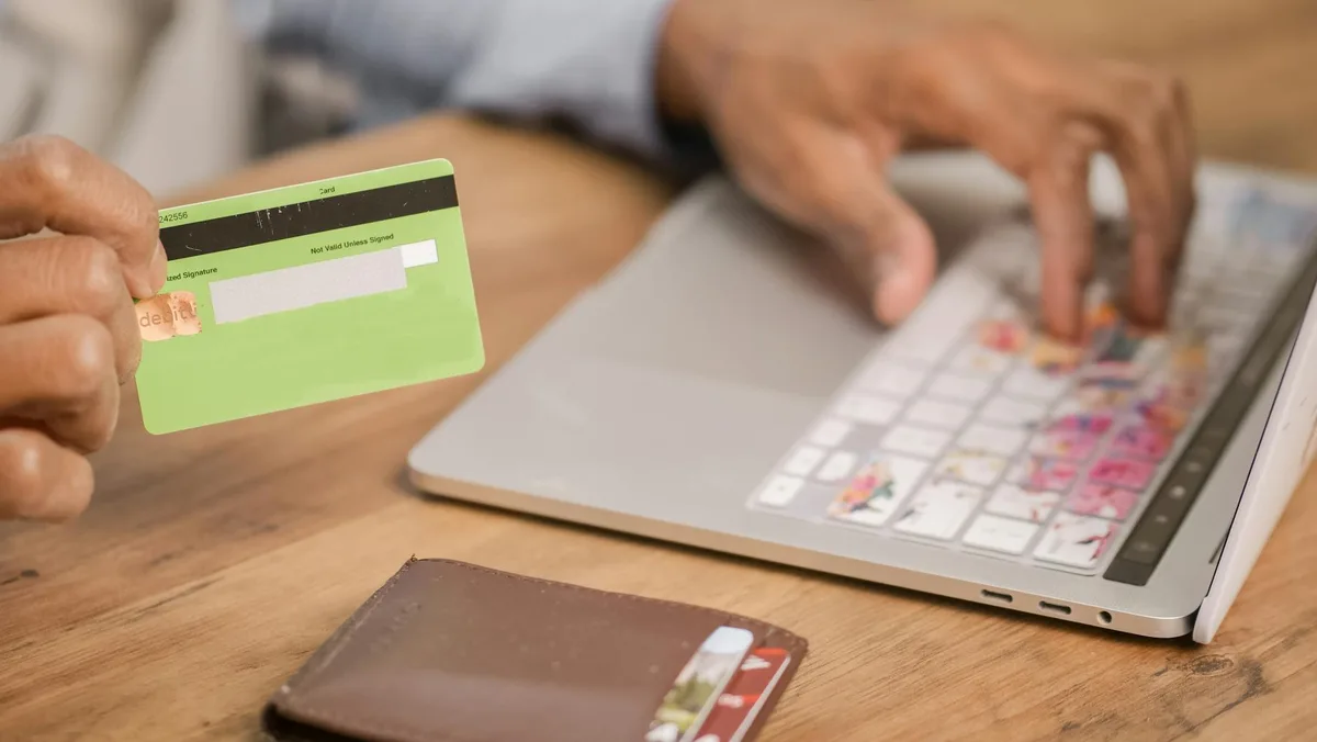 Indonesian ecommerce merchant reviewing BNPL payment program on laptop showing Rupiah transactions and Kredivo checkout interface